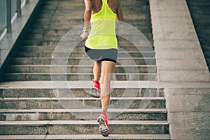 Woman climbing up city stairs jogging and running