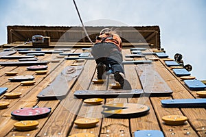 Woman climbing wooden wall with rocks (Palestra) photo