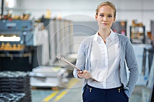 Woman, clipboard and factory in portrait for logistics with quality assurance in facility for inventory. Confident