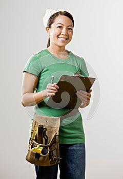 Woman with clipboard and tool belt