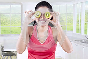 Woman close her eyes with slices of kiwi fruit