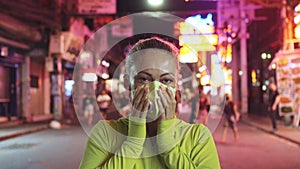 Woman close up look caucasian at Pattaya Walking Street with wearing protective medical mask. Lockdown quarantine