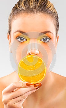 Woman close up with a orange slice