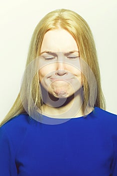 Woman with closed eyes hiding lips in mouth