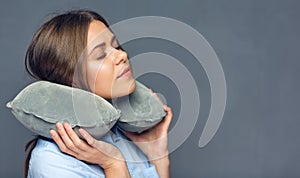 Woman with closed eyes resting with travel pillow.