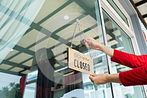Woman closed store with sign board front door shop, Small business come back turning