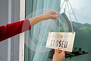 Woman closed store with sign board front door shop, Small business come back turning