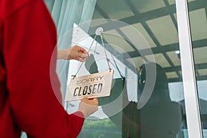 Woman closed store with sign board front door shop, Small business come back turning