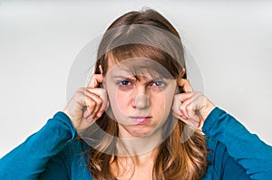 Woman closes ears with fingers to protect from loud noise