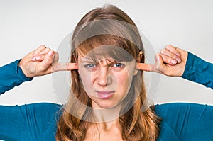 Woman closes ears with fingers to protect from loud noise