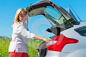 Woman closes the trunk of the car