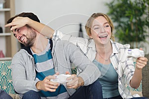 woman closing mans eyes while playing video games