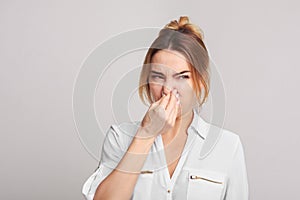 Woman closing nose because of bad smell photo