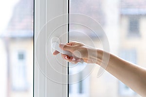 Woman closing pvc window with double glazing