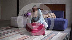 Woman closing and zipping suitcase, getting ready for road trip preparing luggage for vacation