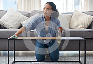 Woman, cloth and cleaning home or table with detergent for dust, bacteria or dirt in living room. Happy female person or