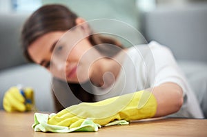 Woman, cloth and gloves for cleaning table with spray, chemical and hygiene in home living room. Girl, cleaner and
