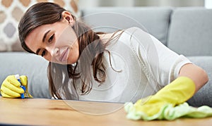 Woman, cloth and gloves with spray on wood table, chemical and cleaning for hygiene in living room. Girl, cleaner and