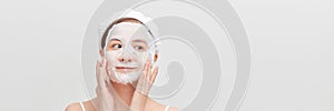 Woman with a cloth moisturizing mask on her face  on white banner background