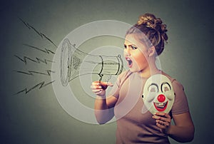 Woman with clown mask screaming in megaphone