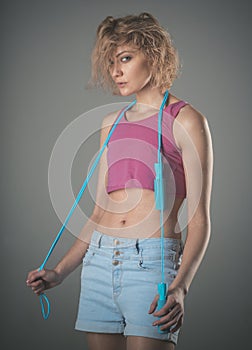 Woman coach with cunning face holds jump rope