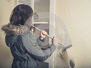 Woman in coast stripping wallpaper