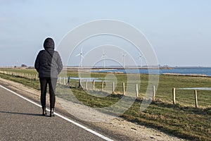 Woman in coat looking at the windmills