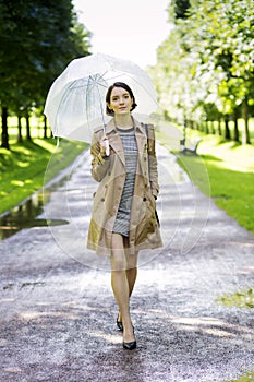 Woman at coat with umbrella at sunny day