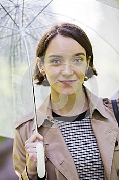 Woman at coat under umbrella since it rains