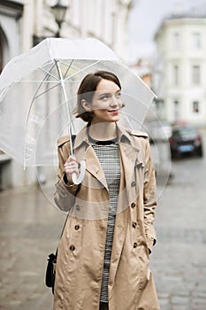 Woman at coat on wet street after rain