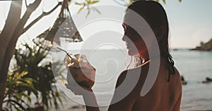 Woman with coconut cocktail relax on tropic island