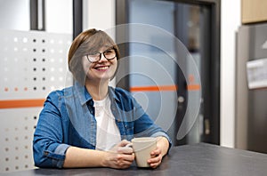 Woman on a coffee break in the office kitchen