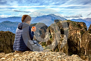 Woman with coffee enjoying scenery on mountain
