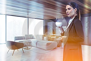 Woman with coffee in gray living room corner