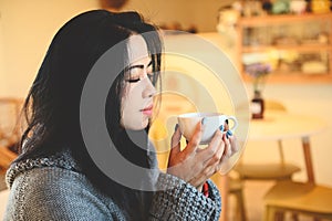 woman coffee with hand holding a cup in cafe, young woman drinking coffee or tea relaxed woman smelling coffee at home in winter