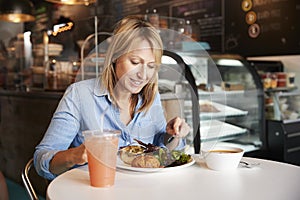 Woman In Coffee Shop Sitting At Table Eating Healthy Lunch