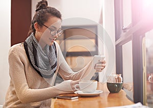 Woman, coffee shop and tablet reading with creative freelancer work and social media in cafe. Website, drink and