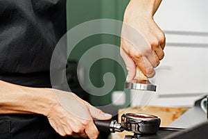 Woman coffee shop worker preparing coffee on professional coffee machine