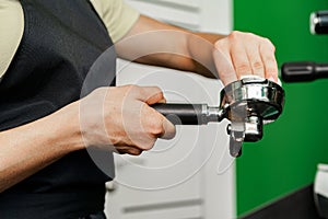 Woman coffee shop worker preparing coffee on professional coffee machine