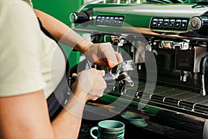 Woman coffee shop worker preparing coffee on professional coffee machine