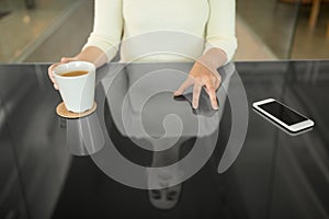 Woman with coffee using black interactive panel