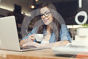 Woman with coffee using laptop