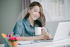 Woman with coffee using laptop.