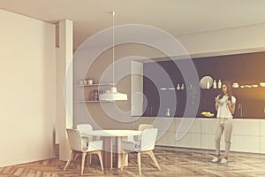 Woman with coffee in white and black kitchen