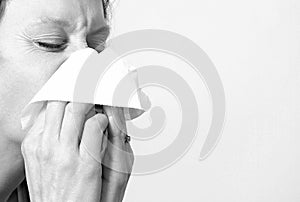 Woman with a cold blowing nose stock photo