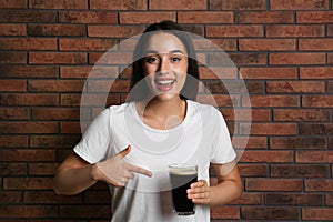 Woman with cold kvass near brick wall. Traditional Russian summer drink