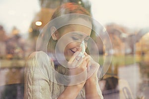 Woman with cold symptoms blowing her nose