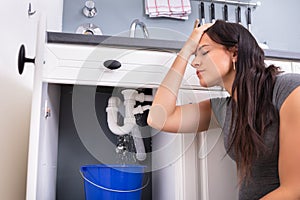 Woman Collecting Leaking Water In Bucket