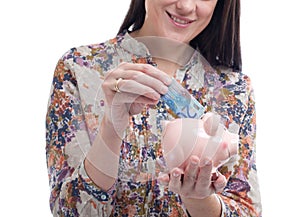 Woman collecting money in a piggy bank