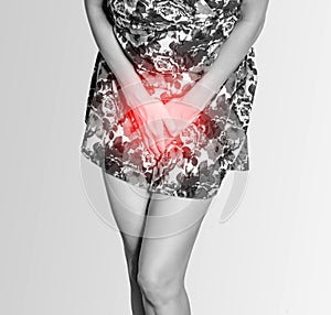 Woman in a colored dress presses her hands to her stomach, experiences pain, inconvenience, and urinary incontinence.